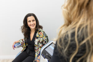 A provider smiles and laughs with a provider during a urinary incontinence treatment in Thunder Bay, ON.