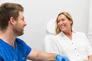 A smiling patient and a provider sit down and discuss Emsculpt in Thunder Bay, ON.