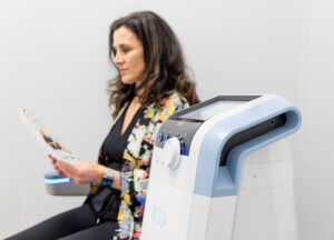 A woman sits on an Emsella chair, at our wellness spa in Thunder Bay, ON